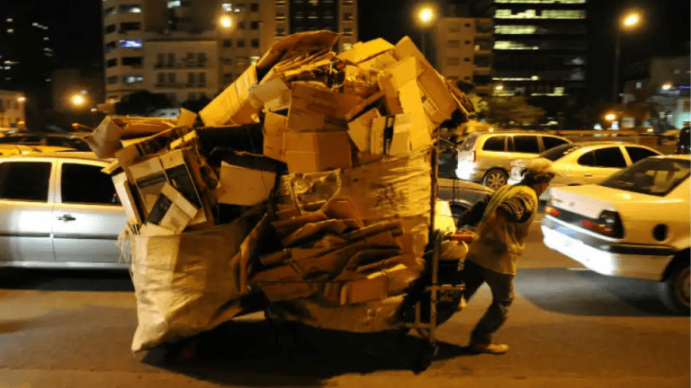 Un cartonero arrastra su carro repleto en plena noche porteña. El hogar del cartonero