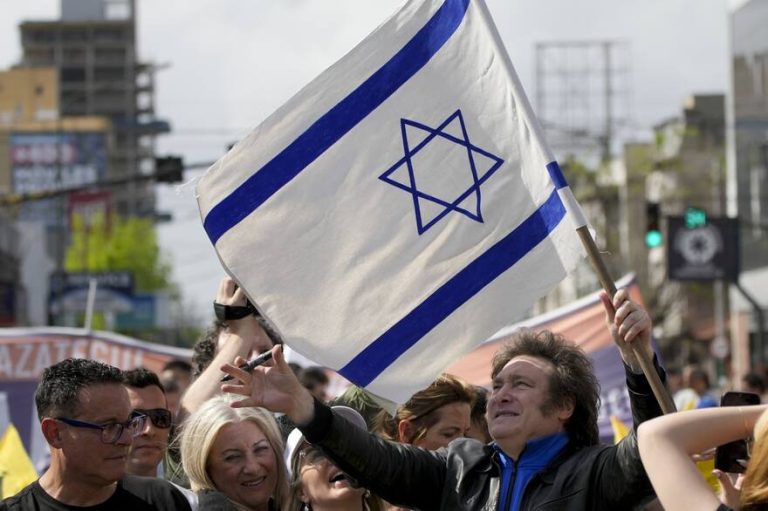 Javier Milei, de la Libertad Avanza, sostiene una bandera israelí durante su caravana por Lomas de Zamora, el lunes 16 de octubre de 2023 Natacha Pisarenko - AP
